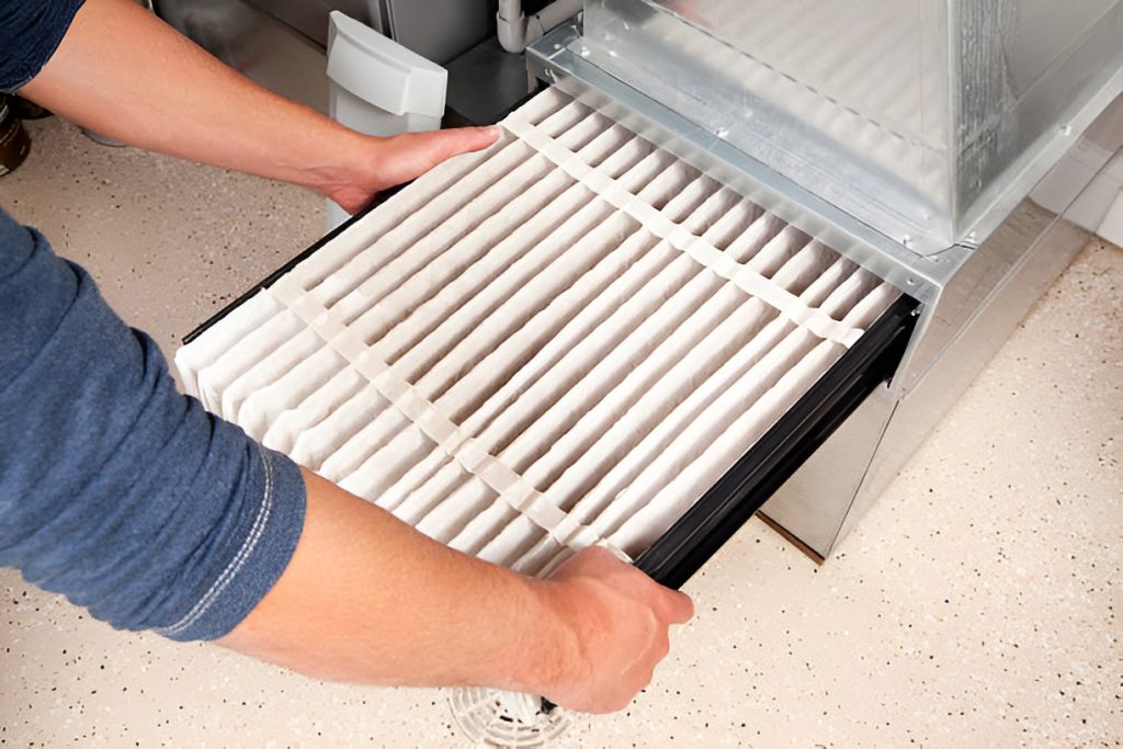 man installing a clean furnace filter